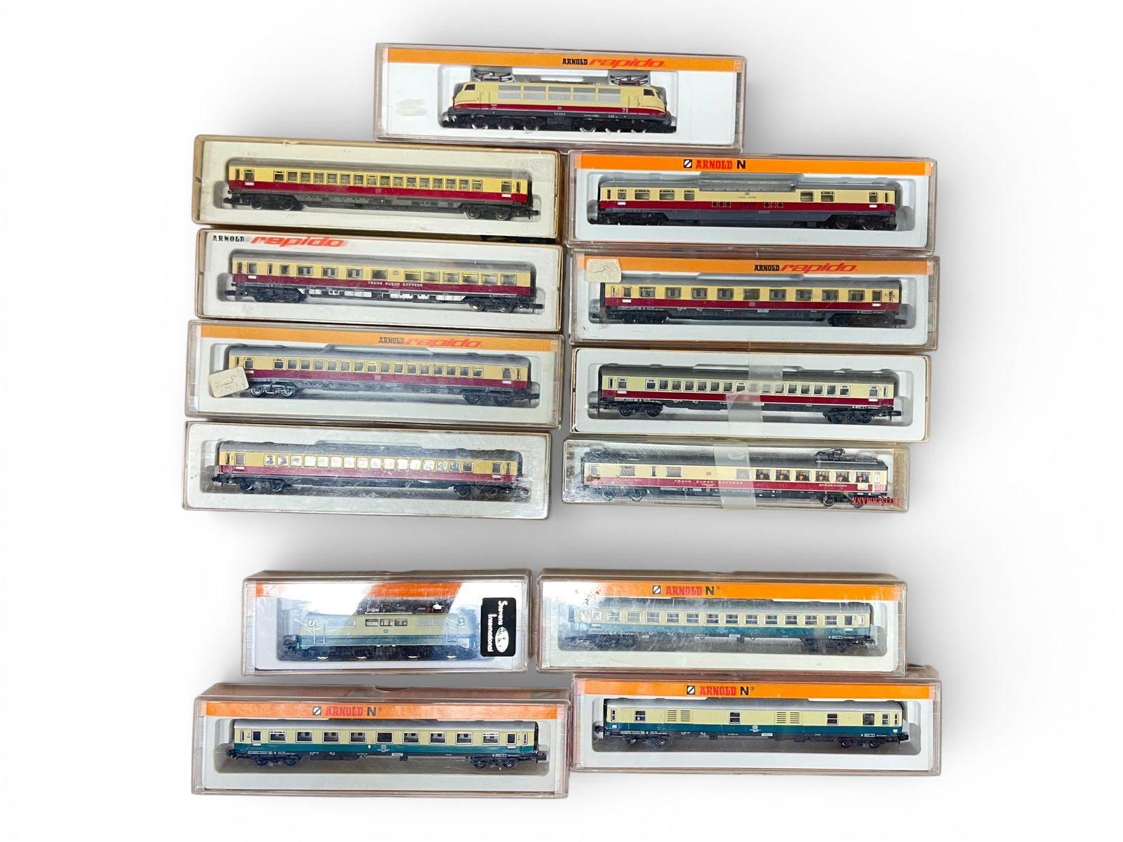 2 Arnold Express Passenger Sets: N Gauge. Includes an 0235 TEE Electric with 8 express cars, some earlier production, colors slightly off, obs; 2325 DB Electric with 3 express cars. All show light handling with boxes. Shipping: Weiss