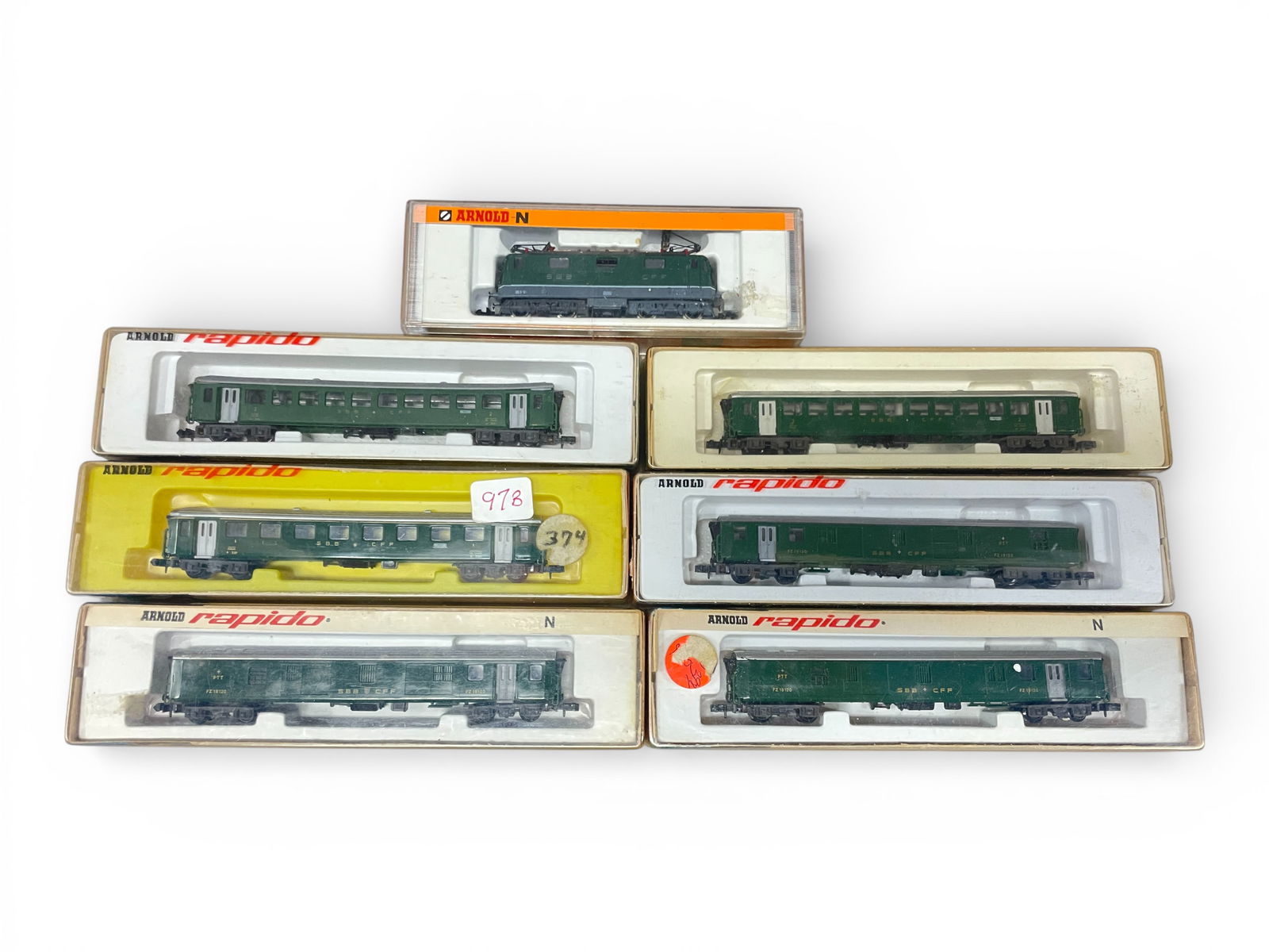 7pc Arnold Rapido Swiss Express Passenger Set: N Gauge. Includes a 2412 SBB CFF Electric loco; Swiss passenger cars- 0371, 2-0372; 3-0375. All show light use with lightly stains boxes.Shipping: Weiss Auctions offers full-service, in-house