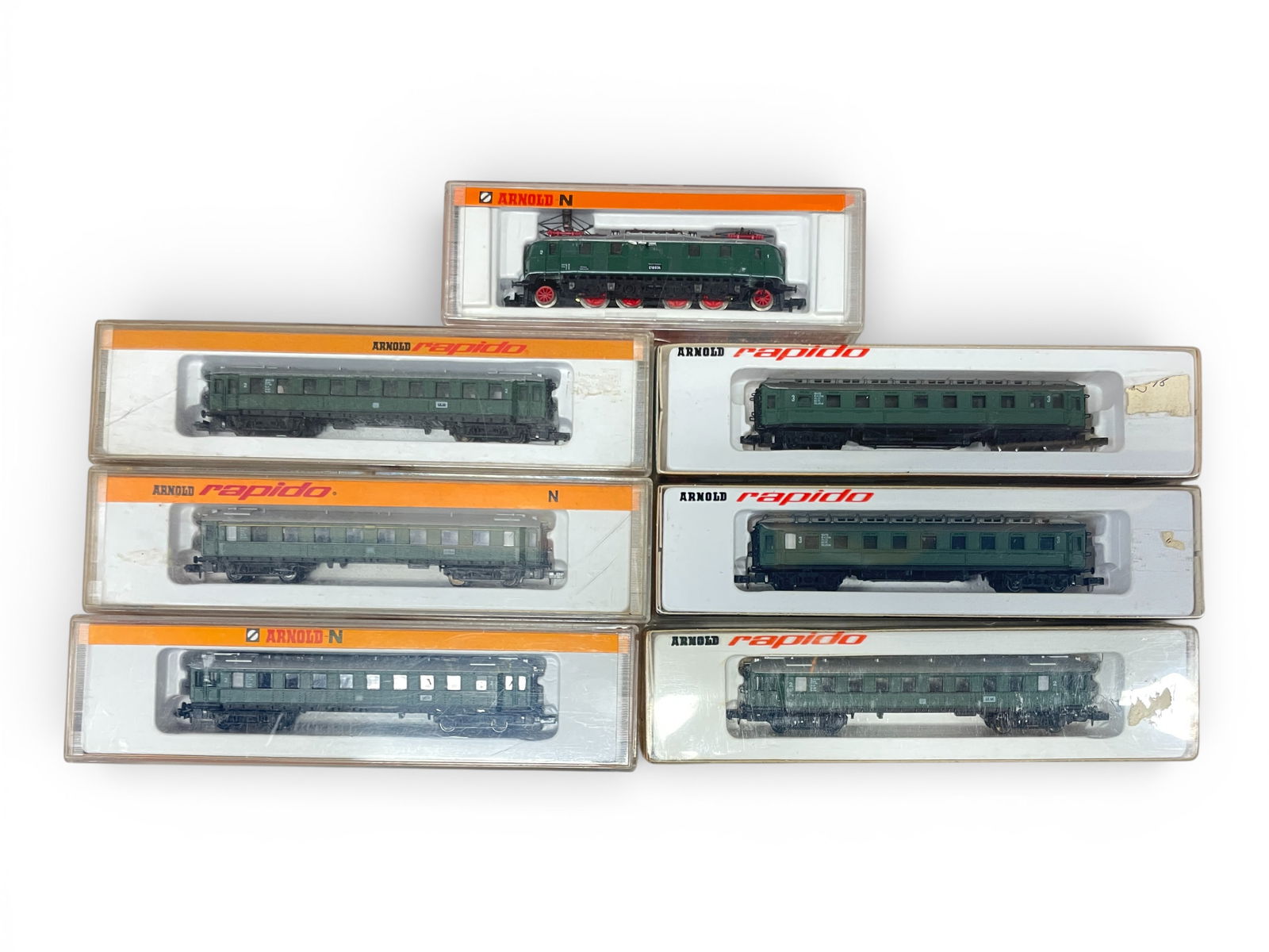 7pc Arnold Rapido German Commuter Train: N Gauge. Includes a 2458 DB E18034 Electric 2-4+4-2;? with 2-331; 2-332 & 2-339 coaches. All show light use with boxes. Shipping: Weiss Auctions offers full-service, in-house shipping for nearly all i
