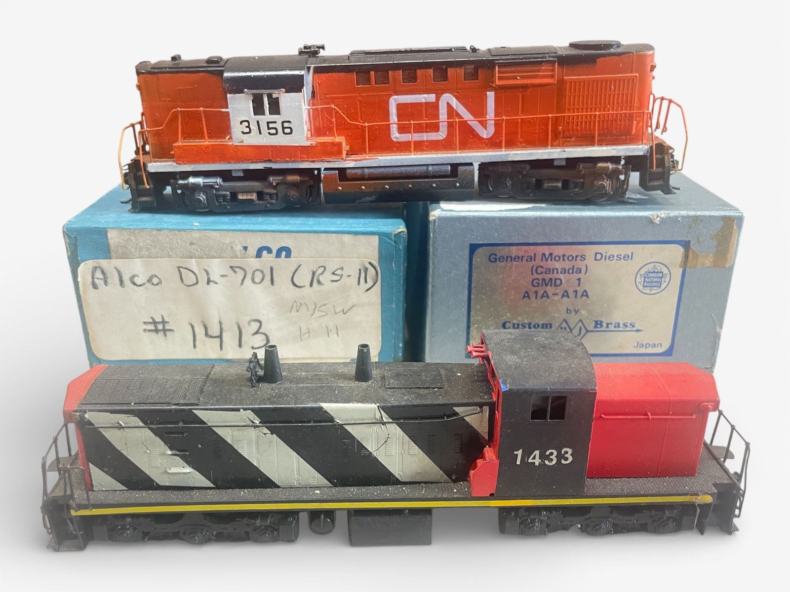 2 Brass HO CN Diesels: HO Gauge. Includes an Alco DL-701 with amateur custom paint job #3156; NJCB GMD 1(Canada) A1A-A1A custom painted #1433, done a bit better than the DL701. They show light use with boxers, GMD1 has foam