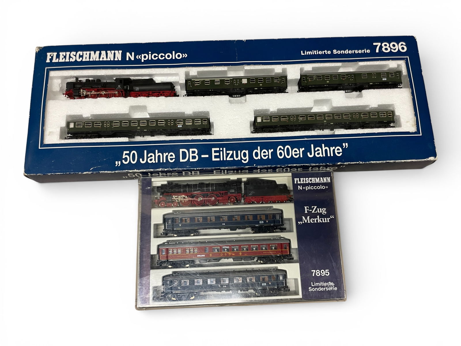 2 Fleischmann Piccalo Train Sets: N Gauge. Includes 7896 5pc DB Commuter Set with a DB36 3348 steam loco with 4 commuter cars; Set 7895 F-Zug set with BR01 1080 4-6-2 steam, loco with 3 Epoch III Express cars. All appear new in