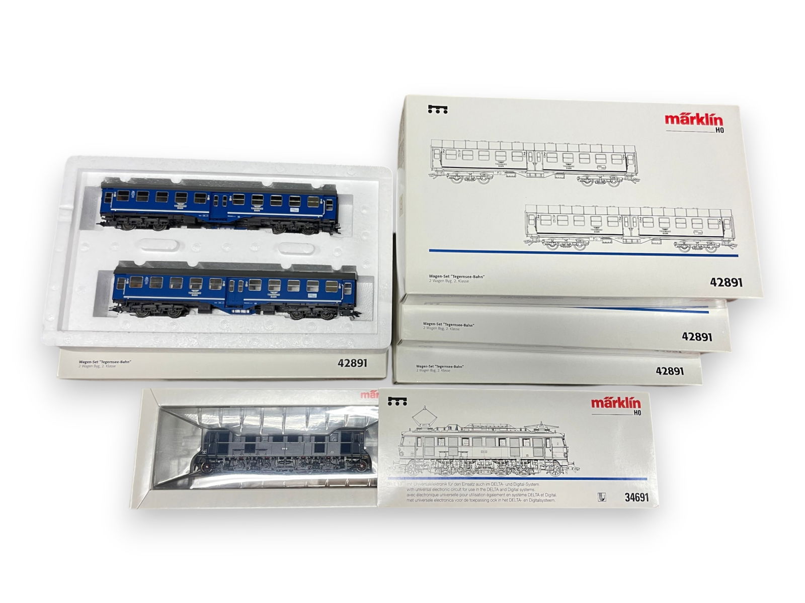 5pc Marklin Tegernsee-Bahn Commuter Set: HO Gauge. Includes a 34691 BR E19 2-8-2 Electric with 4-42891 2-car sets. All appear new in boxes. Shipping: Weiss Auctions offers full-service, in-house shipping for nearly all items in this auction.