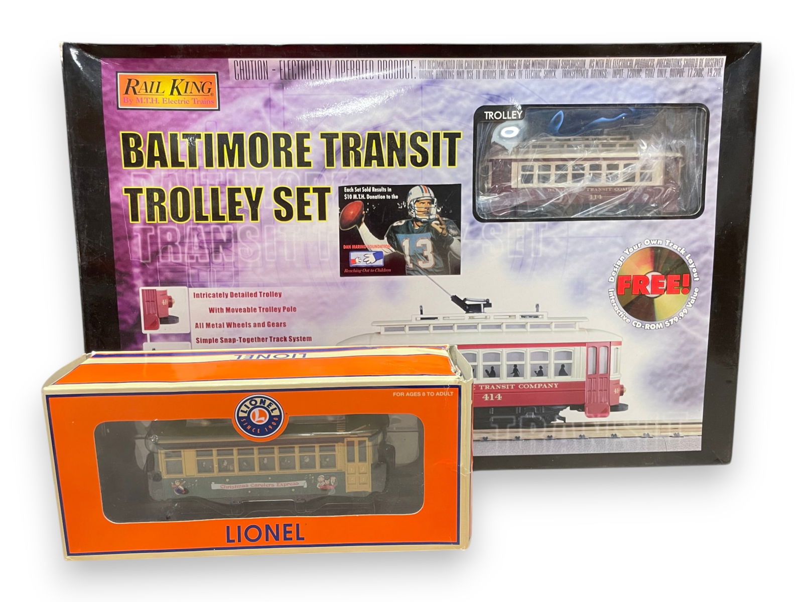Modern Trolley Lot: Includes an MTH 30-4027-0 Baltimore Transit Trolley Set with Trolley, RealTrax and transformer, new in set box; Lionel 28434 Christmas Bump'n Go Trolley showing light use.Shipping: Weiss Auctions