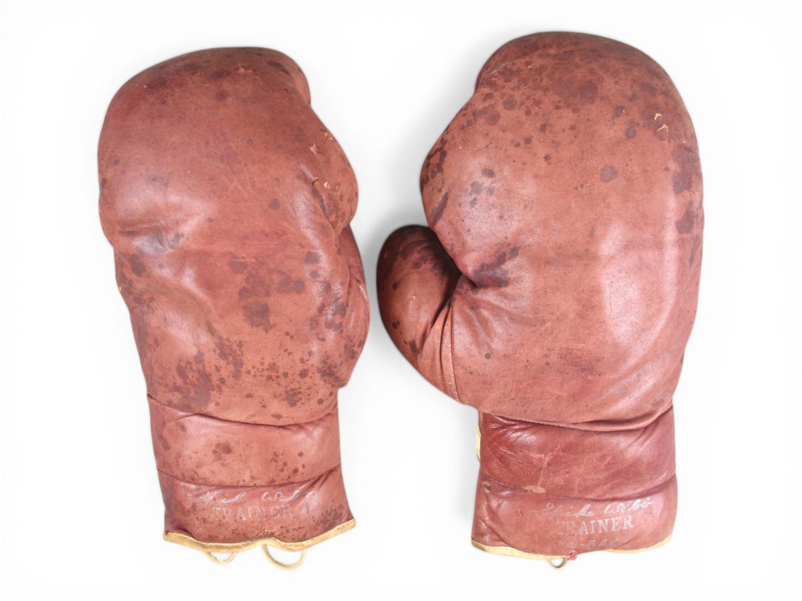 Spike Webb Boxing Trainer Gloves: Pair of vintage leather lace-up boxing gloves stamped "Spike Webb - Trainer #60-5445." The gloves exhibit heavy wear, surface spotting, and rich patina consistent with extensive gym and training use. 