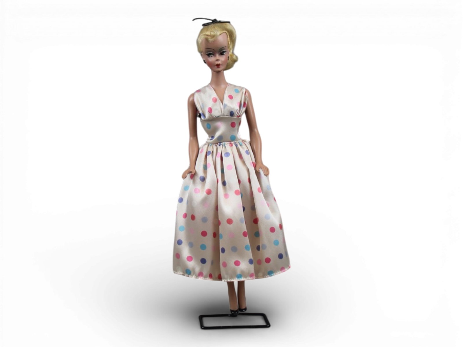 Original German Bild Lilli Doll, 11-1/2": German "Bild Lilli", 11-1/2" doll with molded and painted facial features, side-glancing eyes with molded lashes, high arched eyebrows, blonde inset wig styled in a ponytail with curl on her forehead,