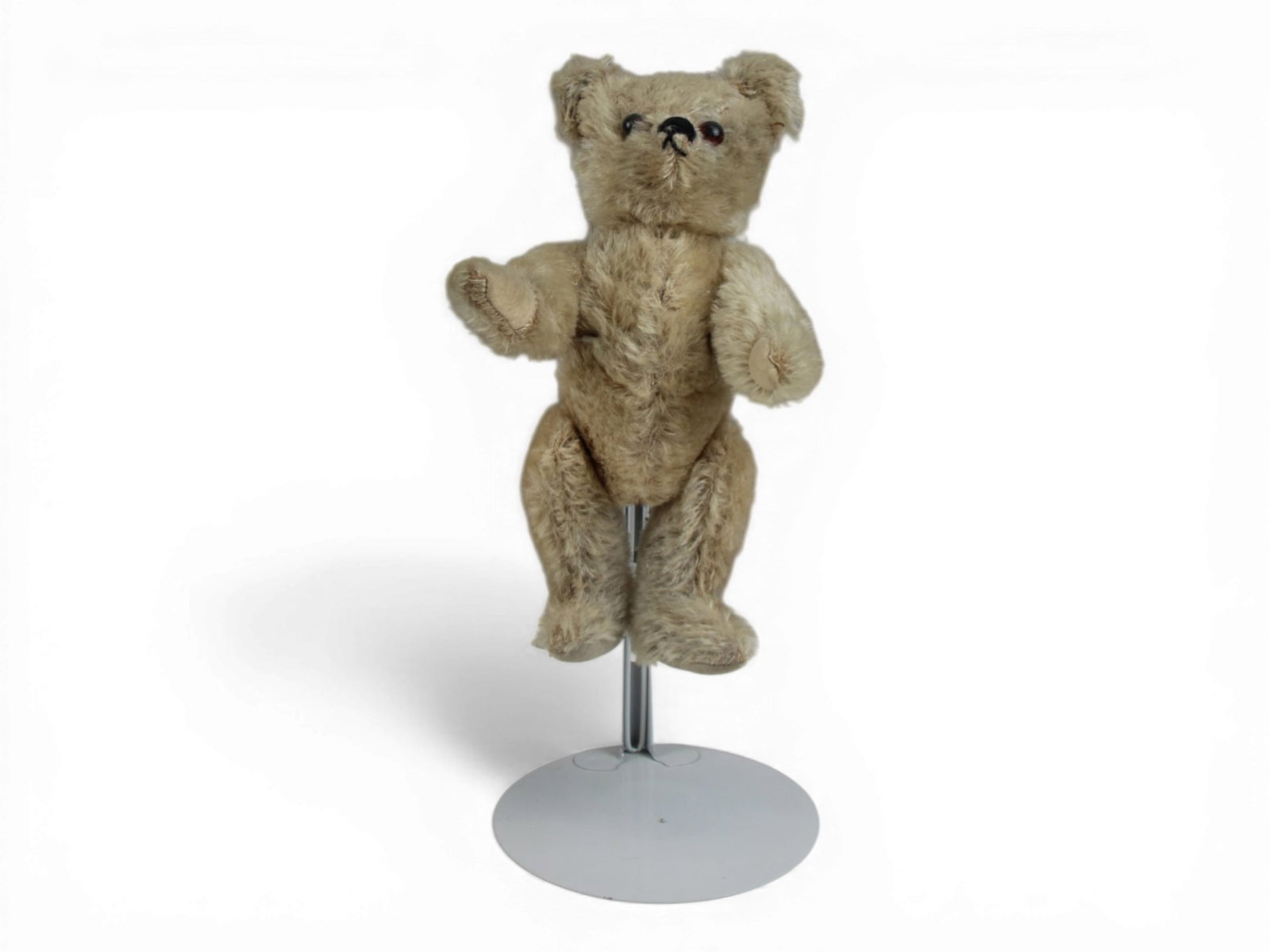 Possibly English Muzzle Teddy Bear: 11 inch tan mohair bear with jointed limbs and glass eyes. Circa 1930s. Good condition. Shipping: Weiss Auctions offers full-service, in-house shipping for nearly all items in this auction. For a