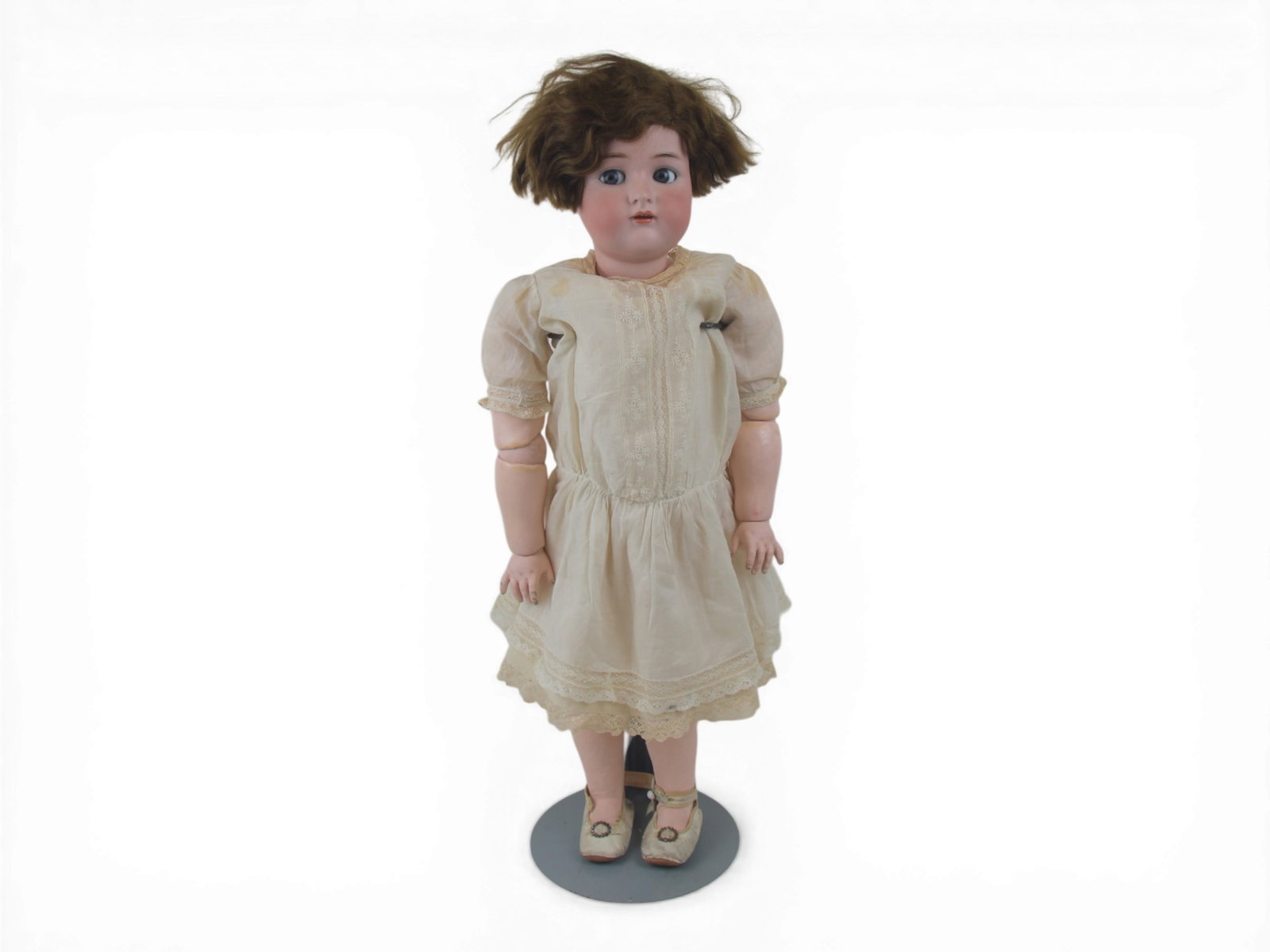 K&R Flirty Doll: 28 inch bisque socket head with flirty eyes on fully jointed composition and wood body with original clothes and wig. Circa 1910. Shipping: Weiss Auctions offers full-service, in-house shipping for ne