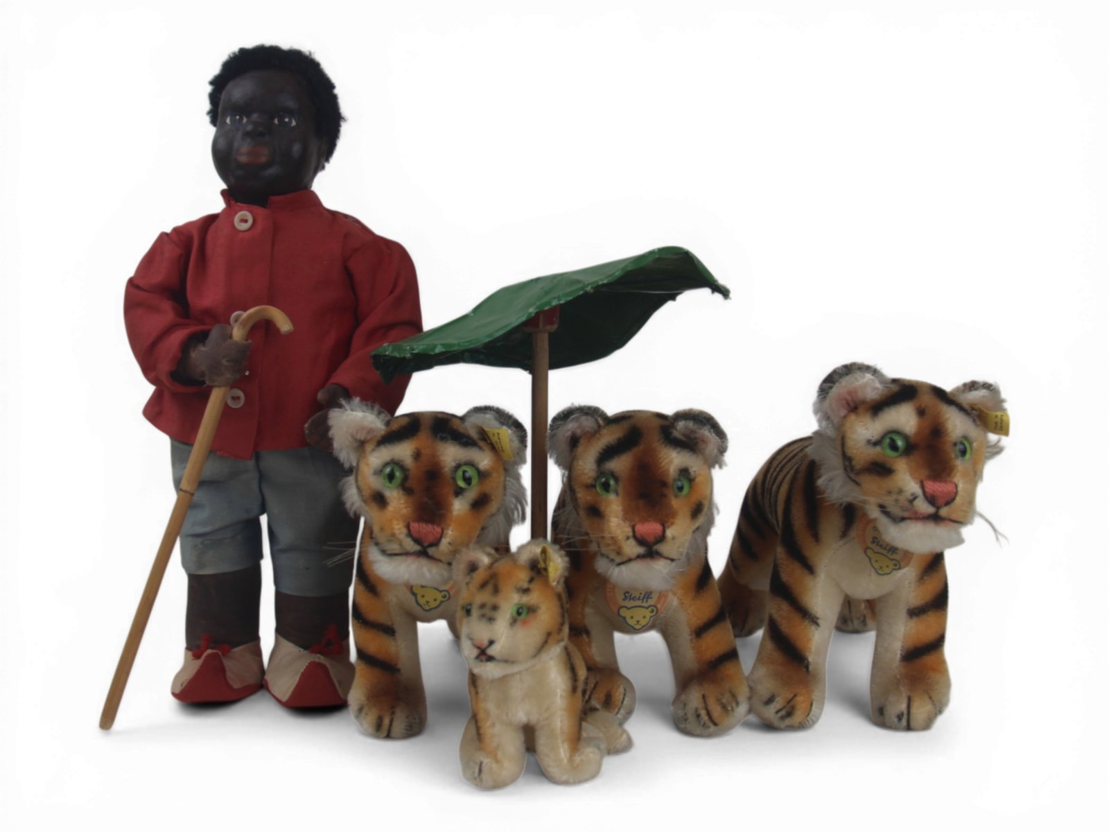 (5) Sambo Doll and Steiff Tigers Group: 13 inch oilcloth doll portraying Little Black Sambo with walking stick and parasol, plus four Steiff tigers including three large examples and one 4.5 inch tiger with silver buttons and green glass ey