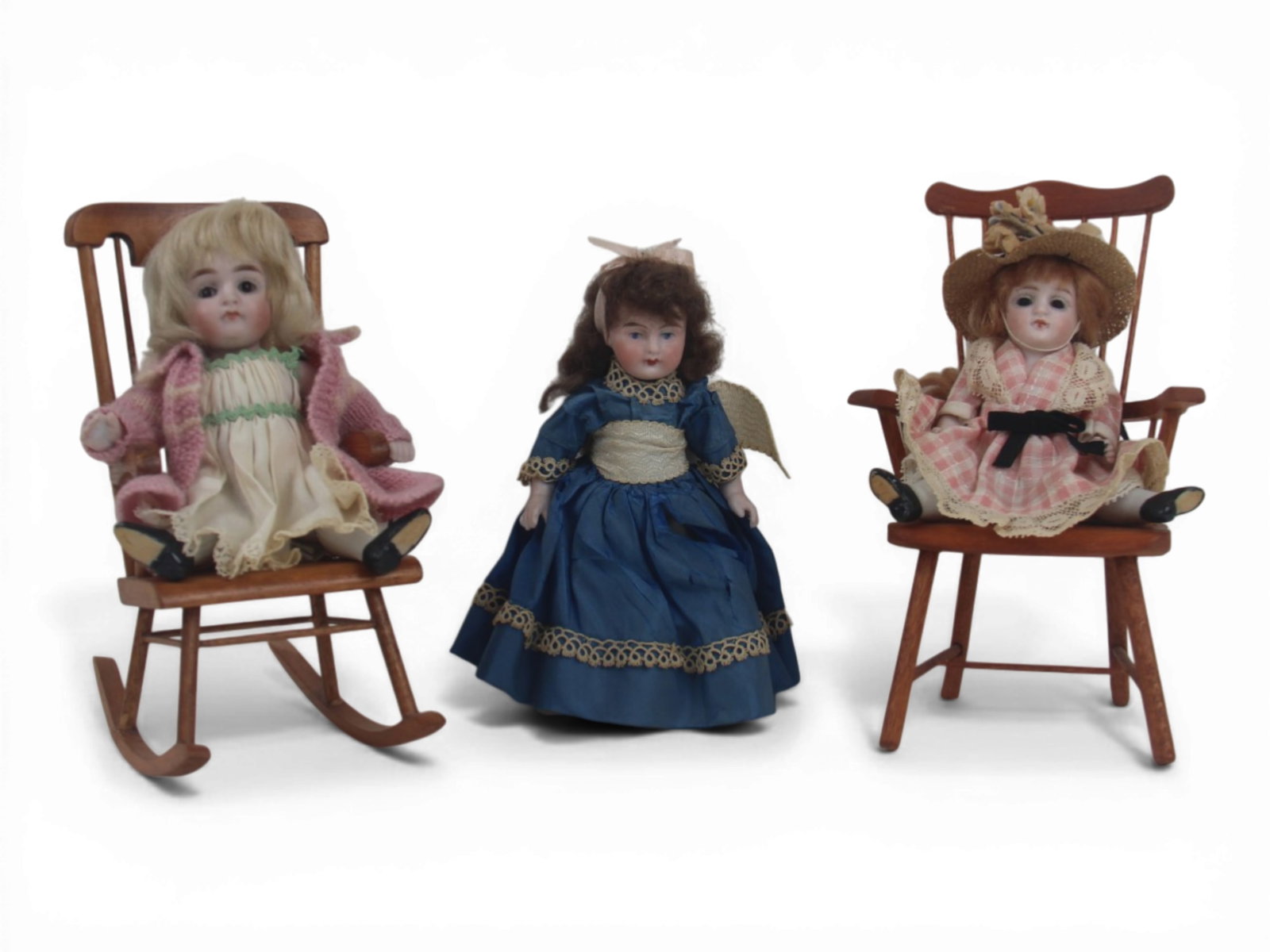 (3) German All Bisque Dolls: Three German all bisque dolls measuring 6 to 5 inches jointed at shoulders and hips with costumes and original wigs, accompanied by two chairs. Circa 1910. Shipping: Weiss Auctions offers full-service