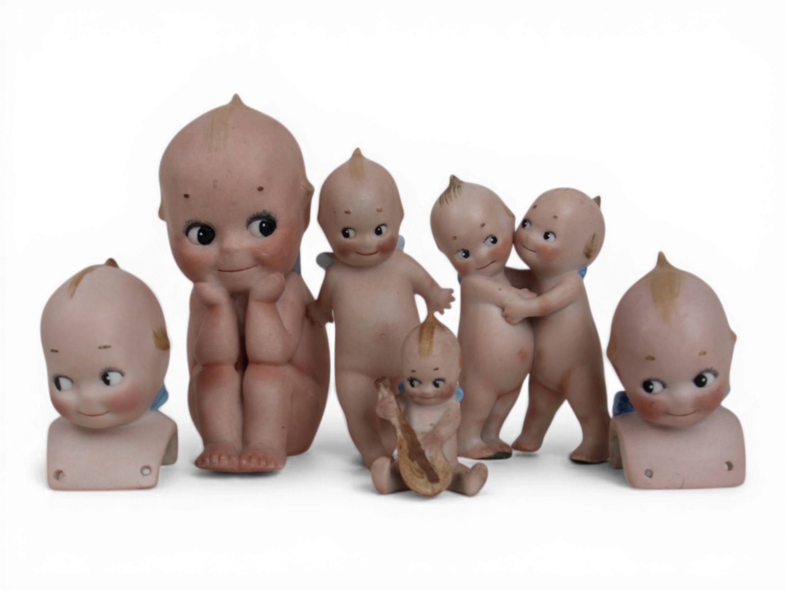 (6) Rose O'Neill Kewpie Figurines: Group of six all bisque Kewpie examples including seated, reclining, embracing couple, two shoulder heads, and a mandolin player. Marked O?Neill. Circa 1913-1923. Shipping: Weiss Auctions offers