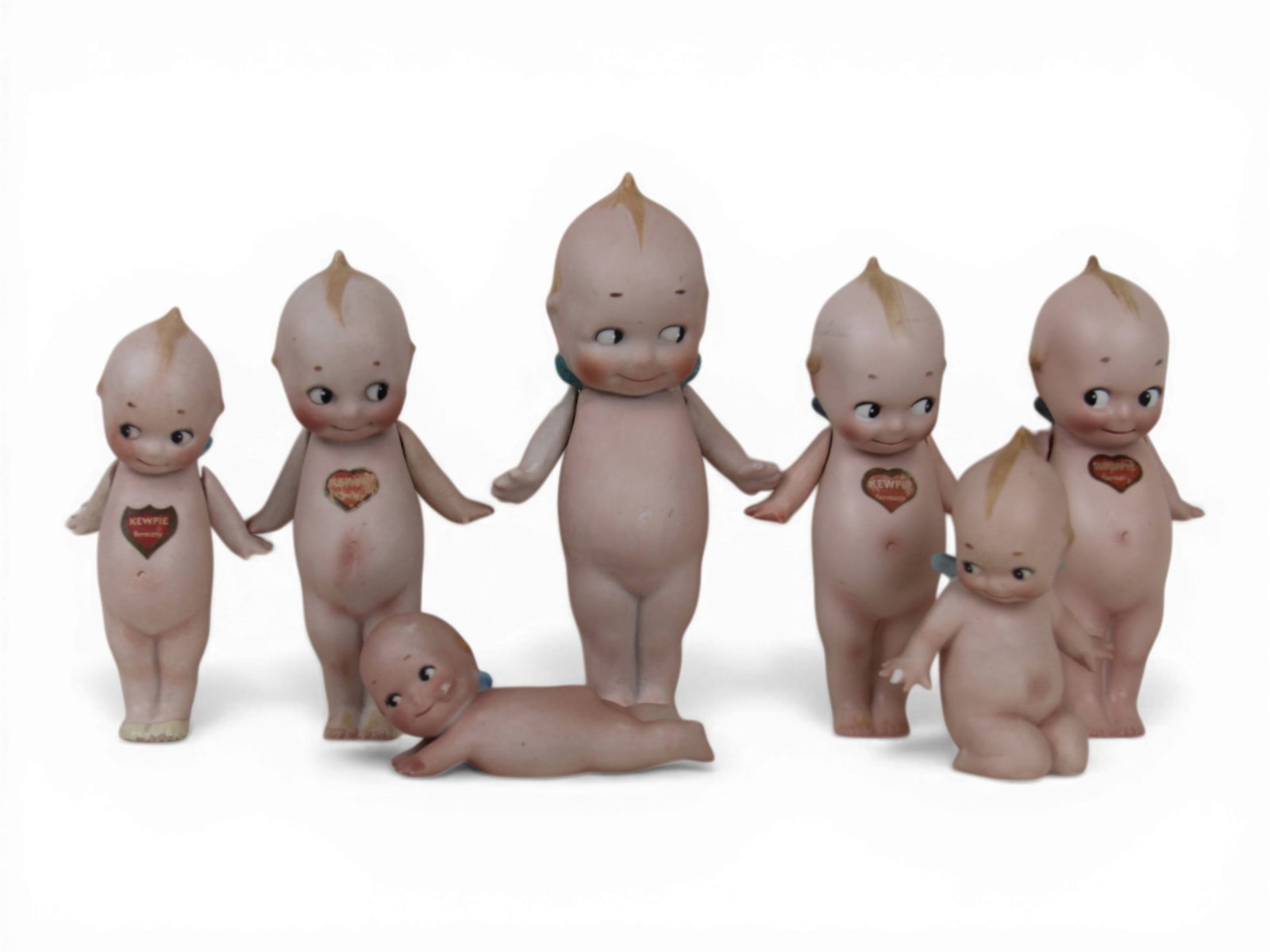 (7) Rose O'Neill Kewpie Dolls: Group of seven all bisque Kewpie dolls measuring 7 to 3.5 inches including standing figures with jointed arms and other poses. Circa 1913-1923. Shipping: Weiss Auctions offers full-service, in-house s