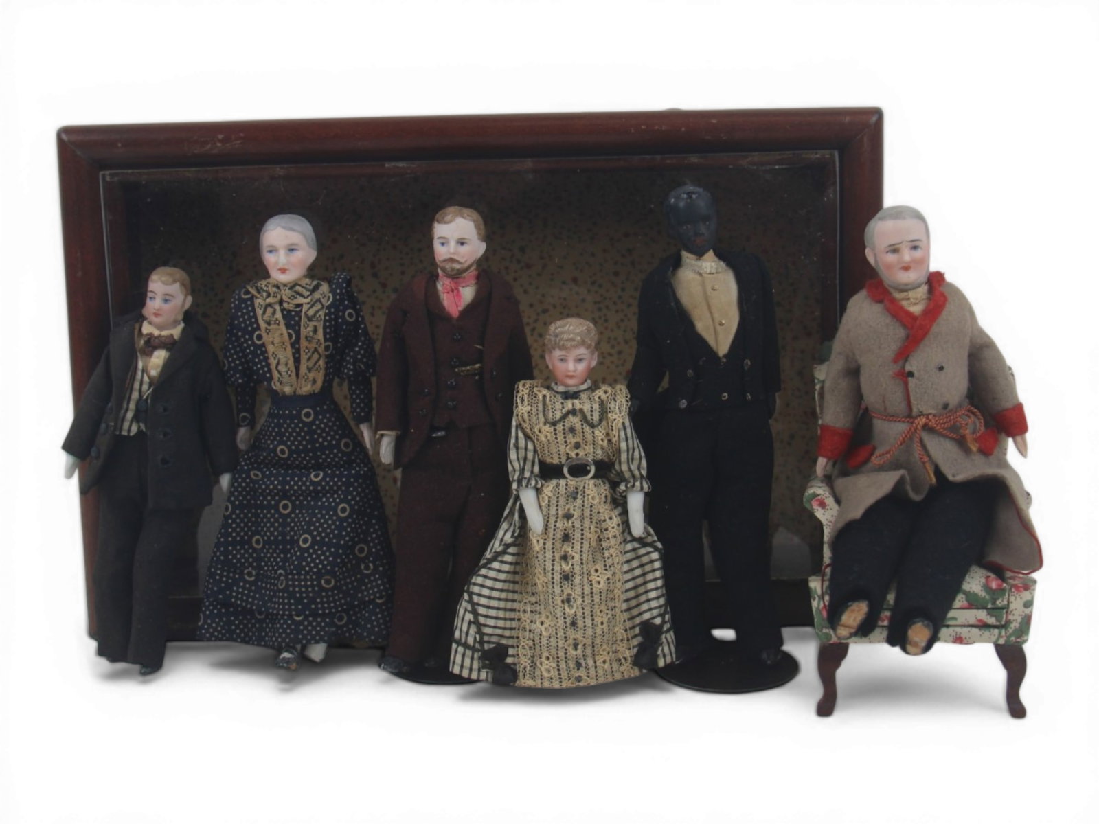 (6) Bisque Head Dollhouse Dolls: Six dollhouse dolls measuring 6 to 5 inches including grandfather, grandmother, gentlemen, lady, and Black gentleman figures in shadow box display. Circa 1900-1920. Shipping: Weiss Auctions offers ful