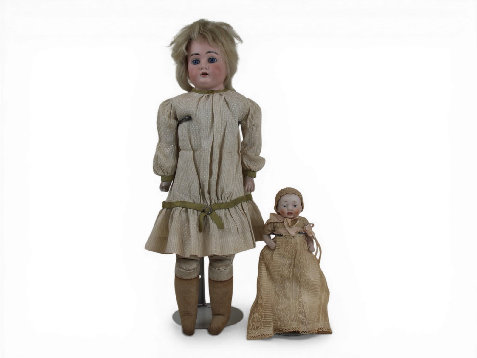 (2) German Dolls: 18 inch bisque shoulder head doll on kidskin body with bisque arms and antique dress, plus a 6 inch all bisque jointed baby doll. Circa 1900-1910. Shipping: Weiss Auctions offers full-service, in-hous