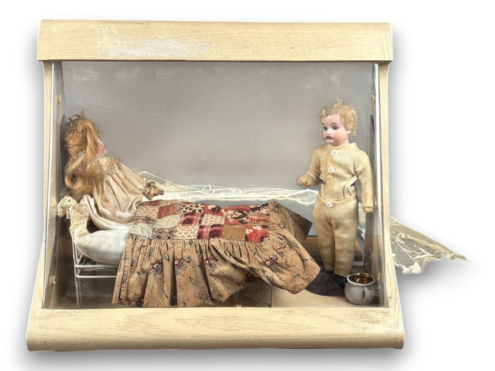 Antique Dolls in Display Case: Two antique bisque head dolls approximately 7 to 8 inches in a bedroom setting with accessories. Modern case measures 15W x 12.5H inches. Dolls circa 1890s. Shipping: Weiss Auctions offers full-servic