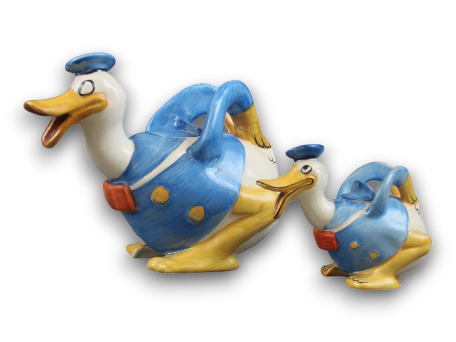 Wade Heath Pottery Donald Duck Teapot Lot of Two: 5 1/2" long and 9" long, both in Very Fine condition. Shipping: Weiss Auctions offers full-service, in-house shipping for nearly all items in this auction. For a shipping quote, please contact us prio