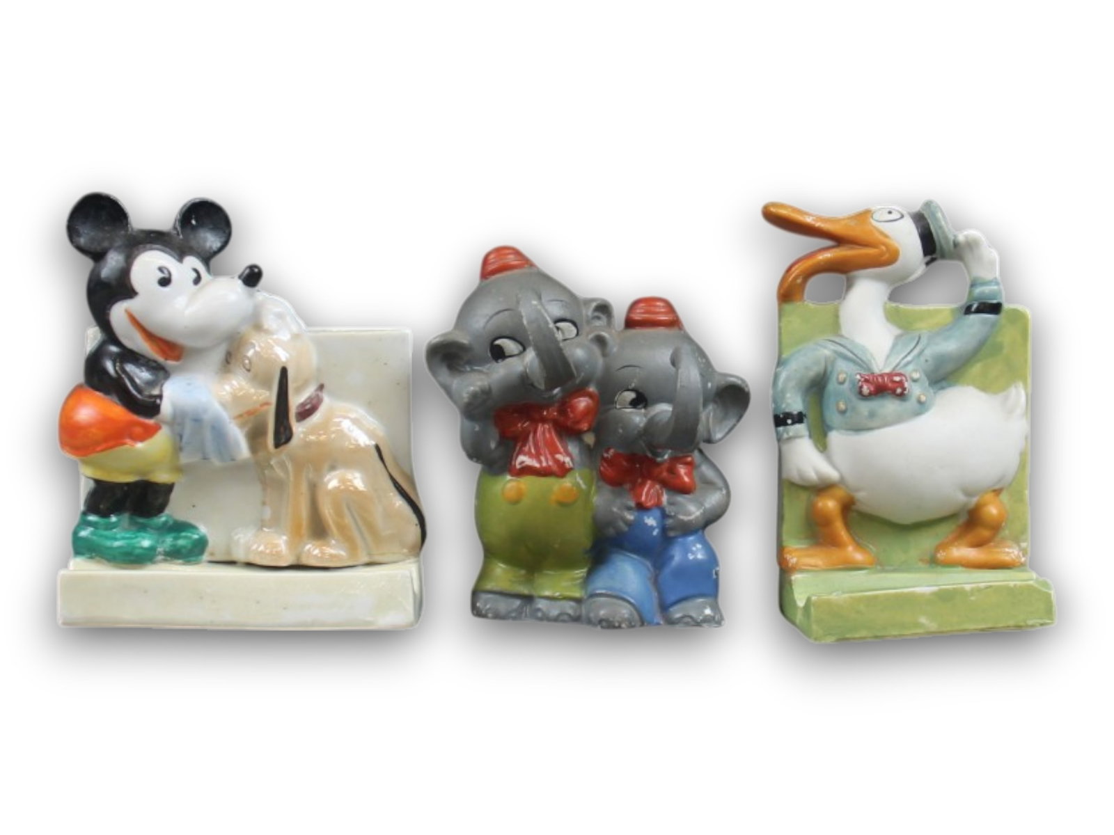 (3) Disney Bisque Toothbrush Holders- Elmer etc.: Group of three vintage Disney bisque toothbrush holders including Mickey Mouse with Pluto, Donald Duck, and the uncommon Double Elmer Elephant example. Some paint loss and surface wear. Mickey approx.