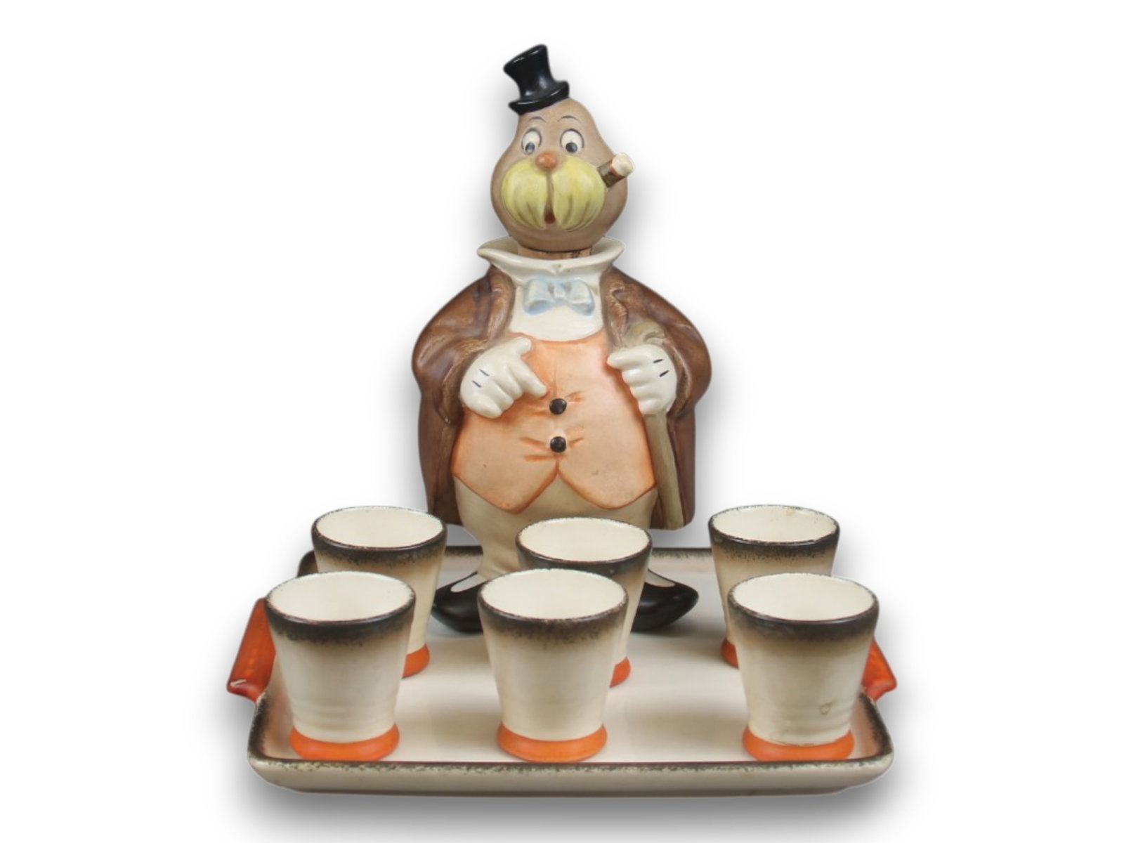 Alice in Wonderland. Rare Goebel Decanter Set: c. 1951. 7.5" tall figural Walrus decanter whose head serves as the removable lid and has cork stopper. Underside has full bee mark and incised "110." together with tray and 6 small cups. Shipping: We