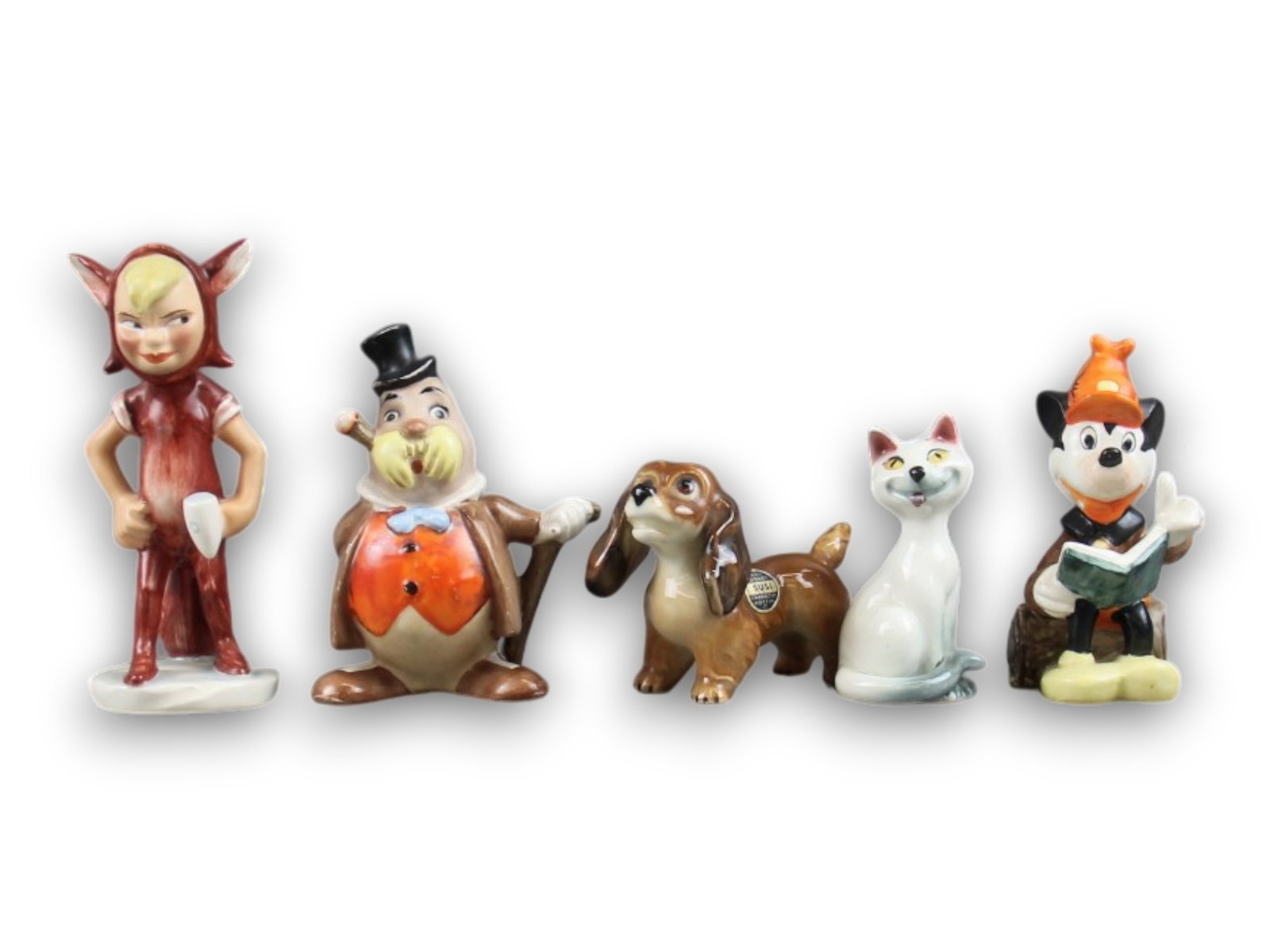 Lot of (5) Disney Goebel Figurines: Includes the largest a 4 1/2" Lost Boy from Peter Pan, Mickey reading a book, Walrus from Alice in Wonderland and two others. Shipping: Weiss Auctions offers full-service, in-house shipping for nearly