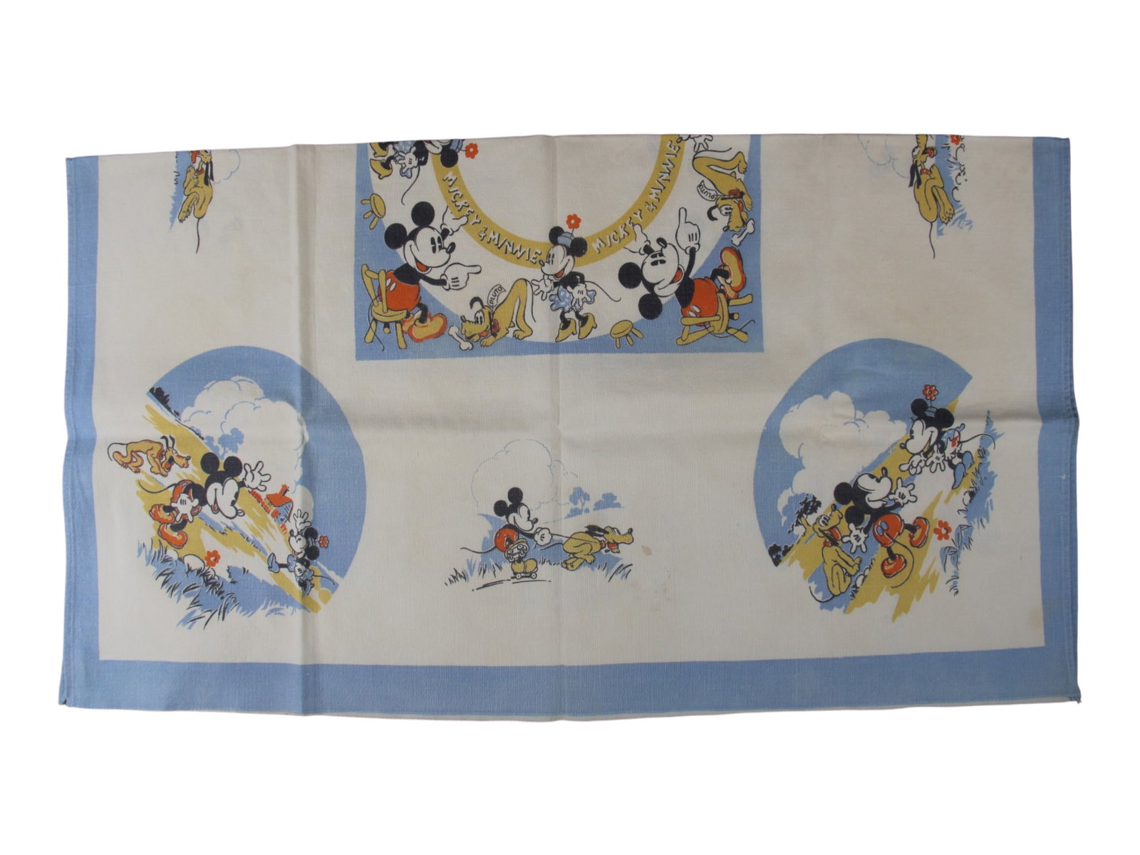 1930/40's Mickey & Minnie Mouse Tablecloth: (Doultonian, circa 1930/40s). British made tablecloth featuring Mickey Mouse, Minnie Mouse, and Pluto in various scenes, printed in blue, yellow, black, and red on white heavy cloth. Appears unused,