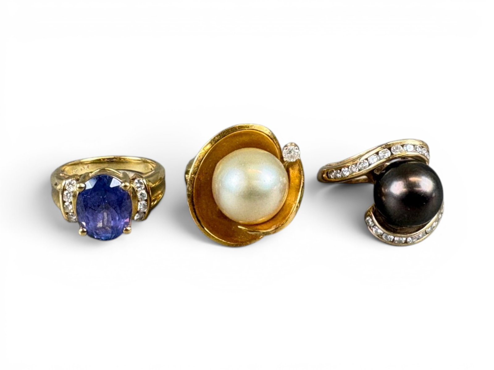 (3) Gold Rings with Pearl & Tanzanite: Group of three gold rings including (i) an 18K yellow gold ring set with a cultured pearl measuring approximately 12 millimeters and a small diamond accent, total weight approximately 13.8 grams.