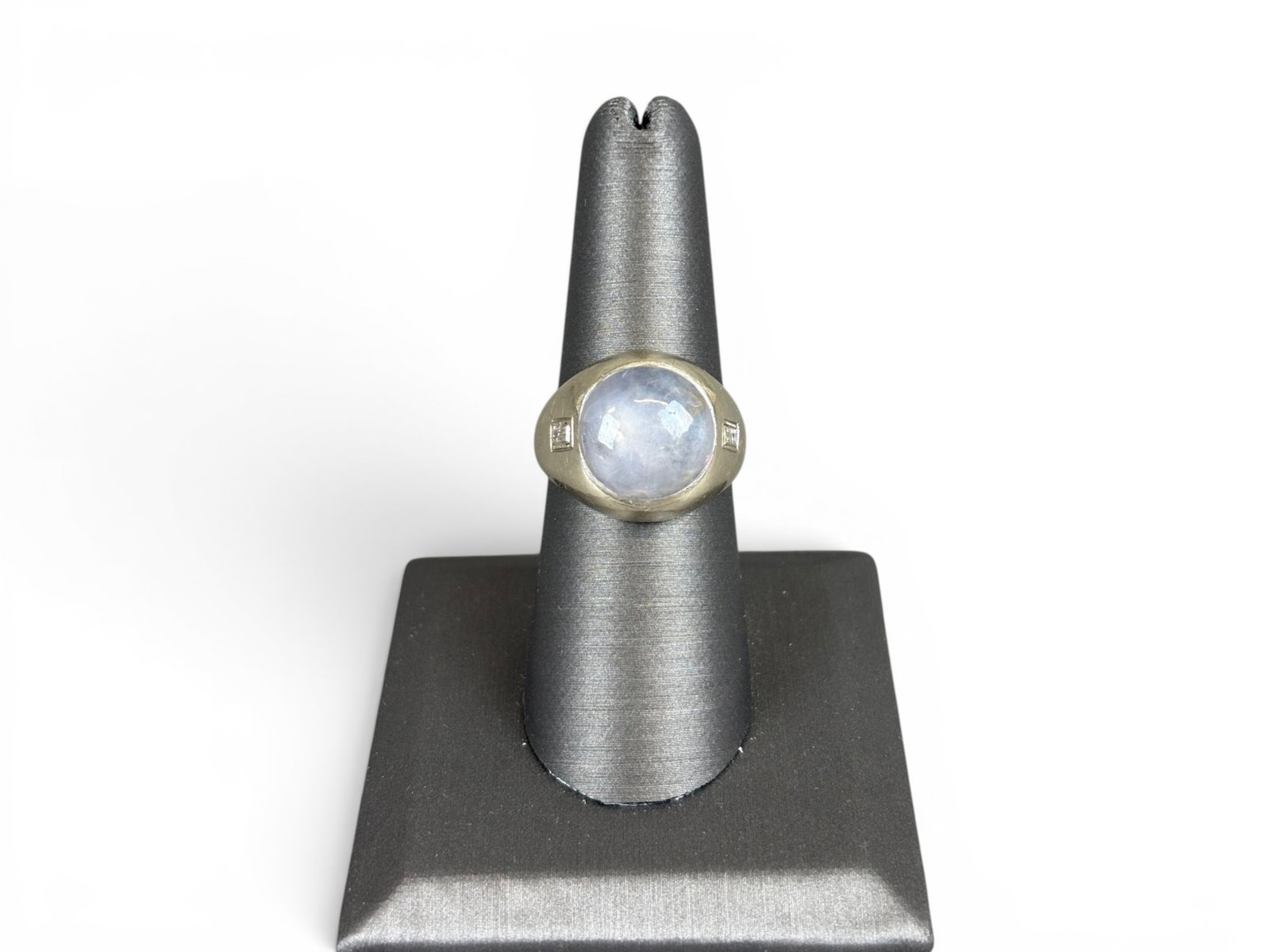 14K Gold Star Sapphire Diamond Ring: 14K white gold ring set with a natural blue star sapphire measuring approximately 12.11 x 12.30 x 5.00 millimeters, estimated weight 8.00 carats. Further set with baguette-cut diamonds at the sides ha