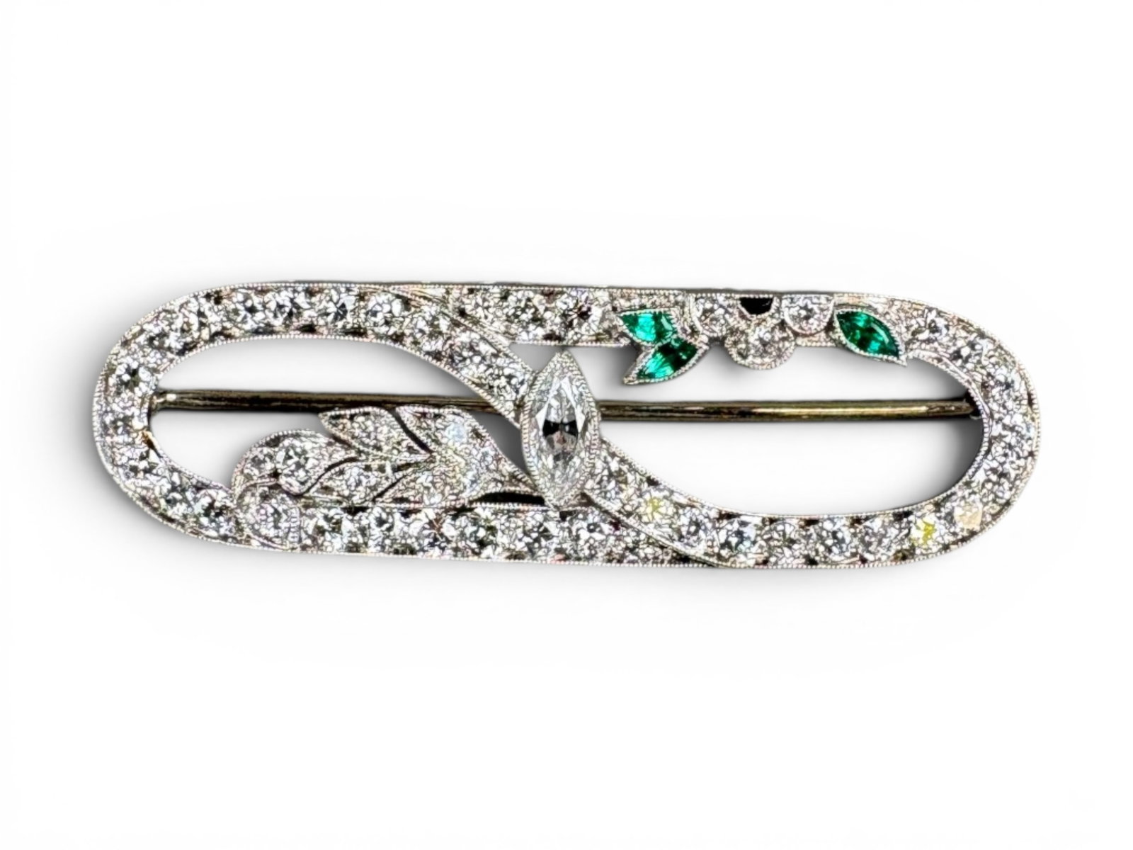 Art Deco Platinum Diamond Emerald Brooch: Art Deco platinum brooch set with diamonds and emeralds, measuring approximately 1 7/8 x 1/2 inches. Total weight approximately 5.6 grams. Shipping: Weiss Auctions offers full-service, in-house shippi