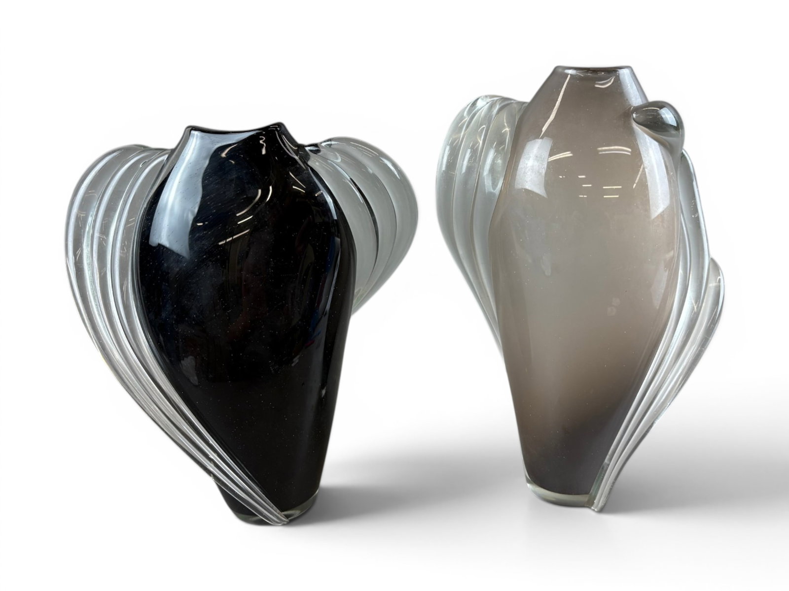 (2) Thomas Buechner III "Vitrix" Art Glass Vases: Two sculptural Thomas Buechner III "Vitrix" studio art glass vases featuring dramatic clear applied ribbed elements extending from the bodies in flowing organic forms. One example displays an opaque