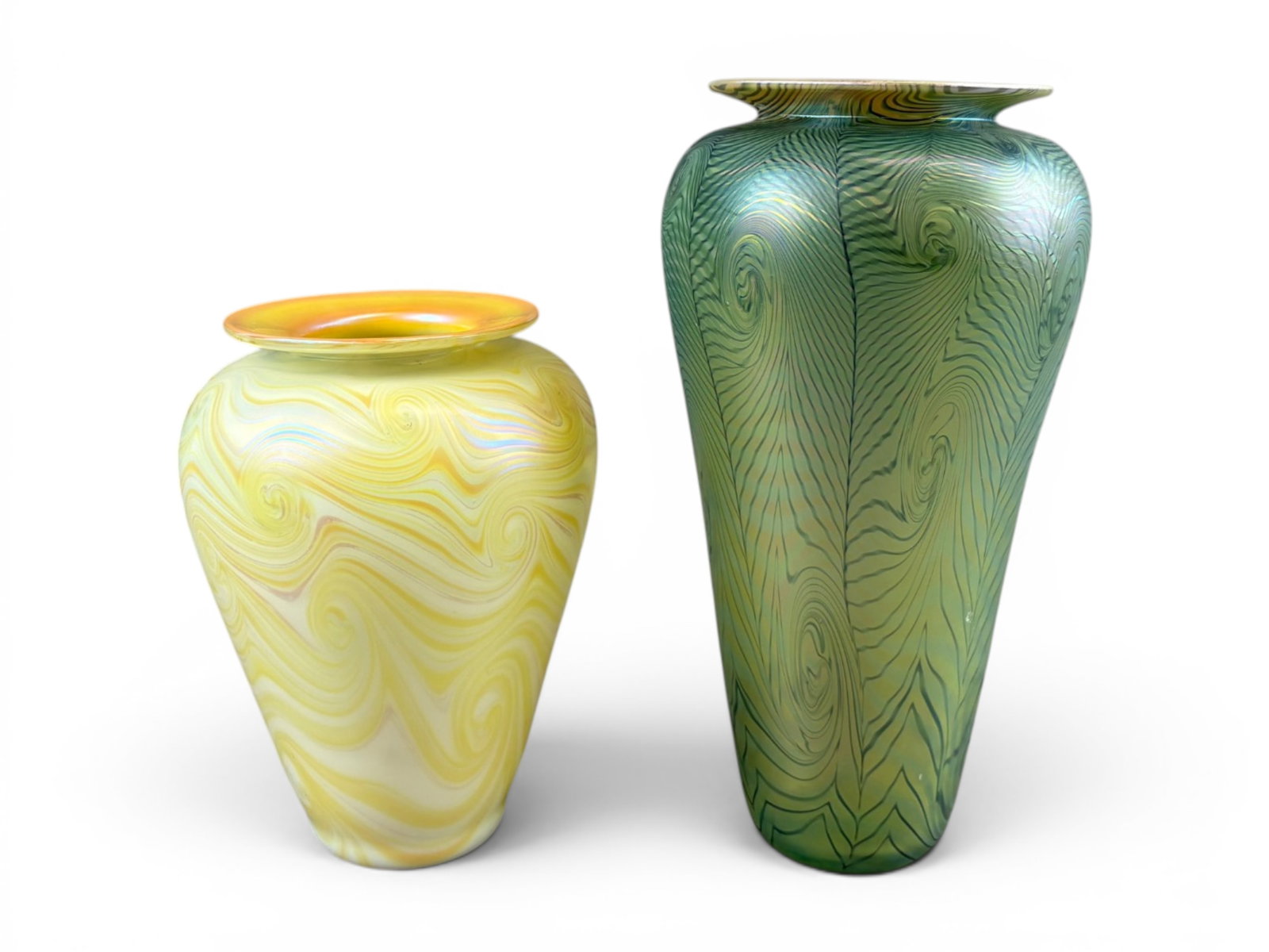 (2) Satava Studio Art Glass Vases: Pair of Satava studio art glass vases featuring iridescent pulled-feather and swirling line decoration. One example displays translucent green coloration with intricate peacock-feather style motifs an