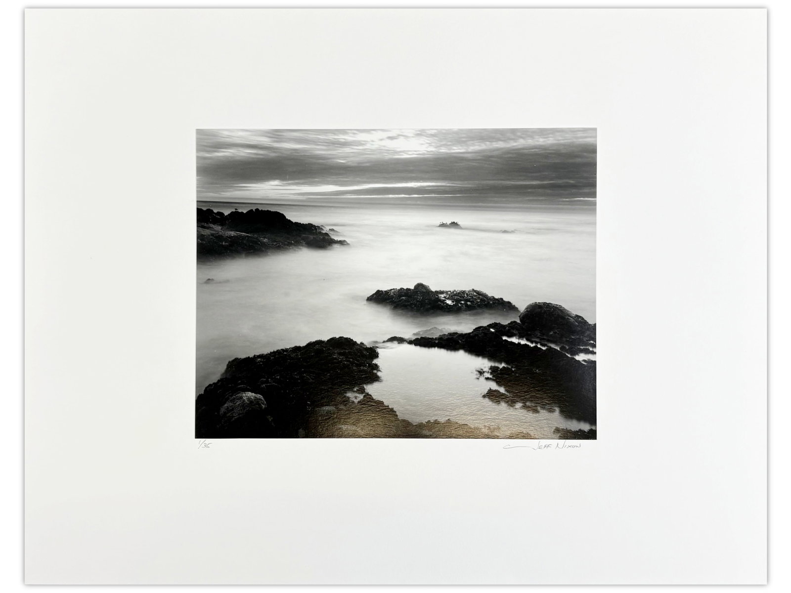 Jeff Nixon Signed Photo, "Big Sur Coastline": Jeff Nixon (American, 1952-2022). Limited edition unframed gelatin silver print, "Coastline, Big Sur, Evening". Pencil signed lower right under image, and pencil numbered 1/35 lower left. Sight seen