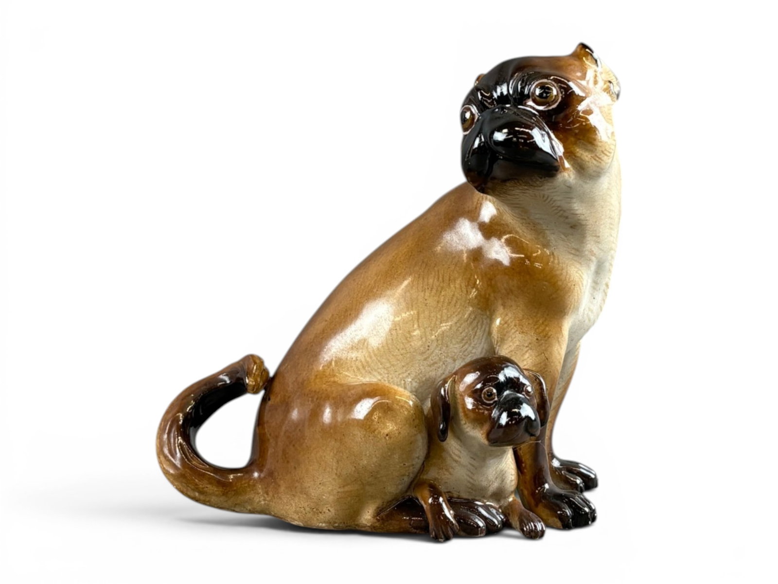 Meissen Porcelain Model of Pug and Puppy: Approx. 7" tall. Depicted looking back over its shoulder, with a puppy in between the legs. Blue crossed swords mark under glaze, impressed "315". Shipping: Weiss Auctions offers full-service, in-hous
