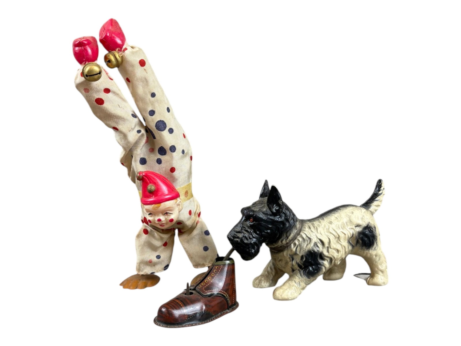 (2) Celluloid Wind-Up Toys: Lot of two vintage celluloid wind-up toys. Includes a 9-inch-tall handstand clown and an 8-inch-long dog holding a tin lithographed shoe in its mouth. Both toys were tested prior to cataloging and fou
