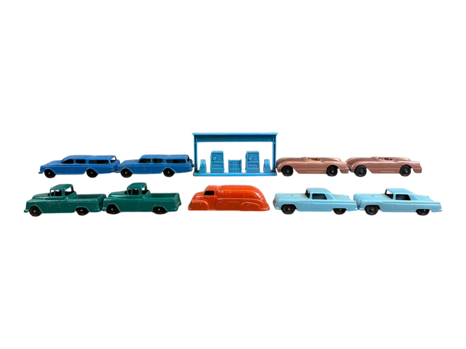 (9) Piece Vintage Tootsietoy Vehicle Lot: Includes Rambler, Chevy Cameo Carrier, Chevrolet Corvette, and Ford Thunderbird. Duplicates present. Each vehicle is approx. 4" long. Also includes blue plastic Tootsietoy Car Service gas pumps. All