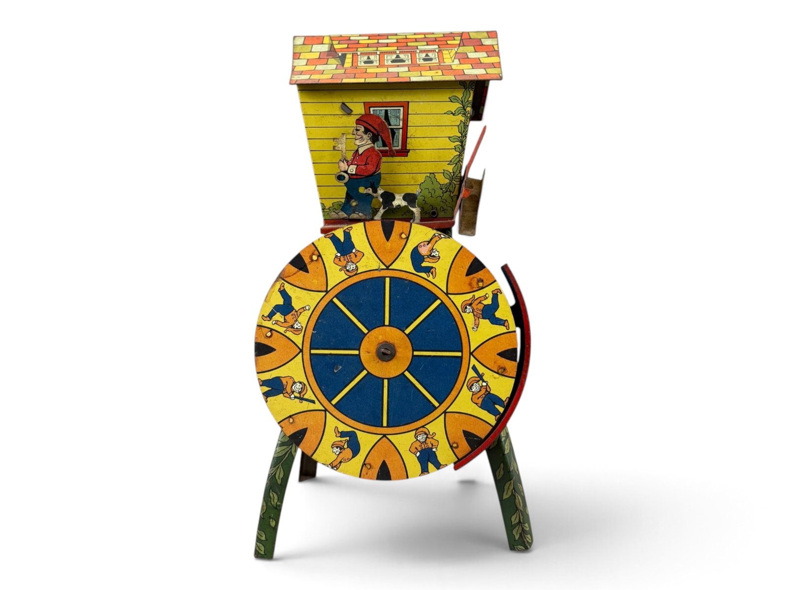 Sandy Andy Merry Miller Toy: Sandy Andy No. 77 "Merry Miller" tin lithographed sand toy measuring approximately 12 inches tall. When filled with sand, the front wheel spins, moving the man and dog along the front of the house.