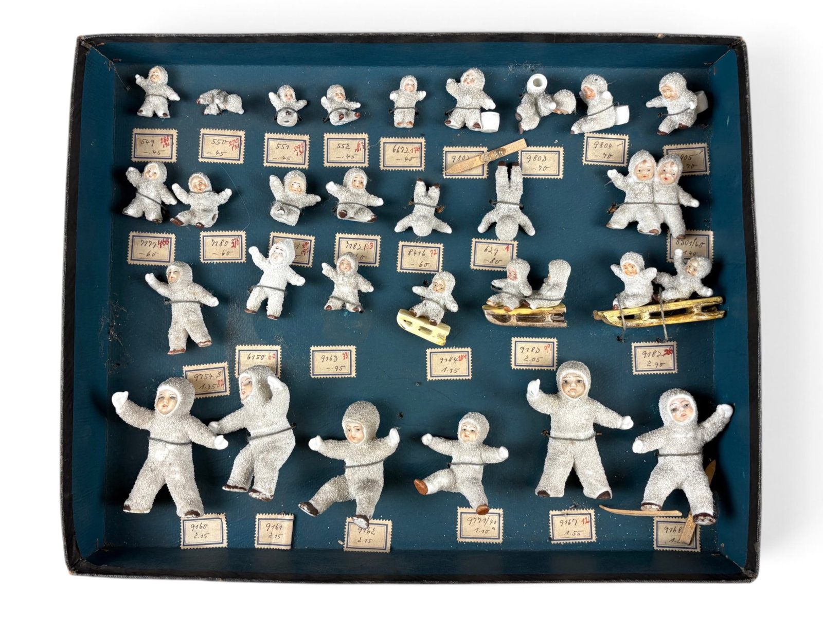 Snow Babies Salesman's Sample: Extremely rare Snow Babies salesman's sample display box containing 28 pieces, including Snow Babies on sleds and with skis. Each piece is individually marked with a number and retains the original