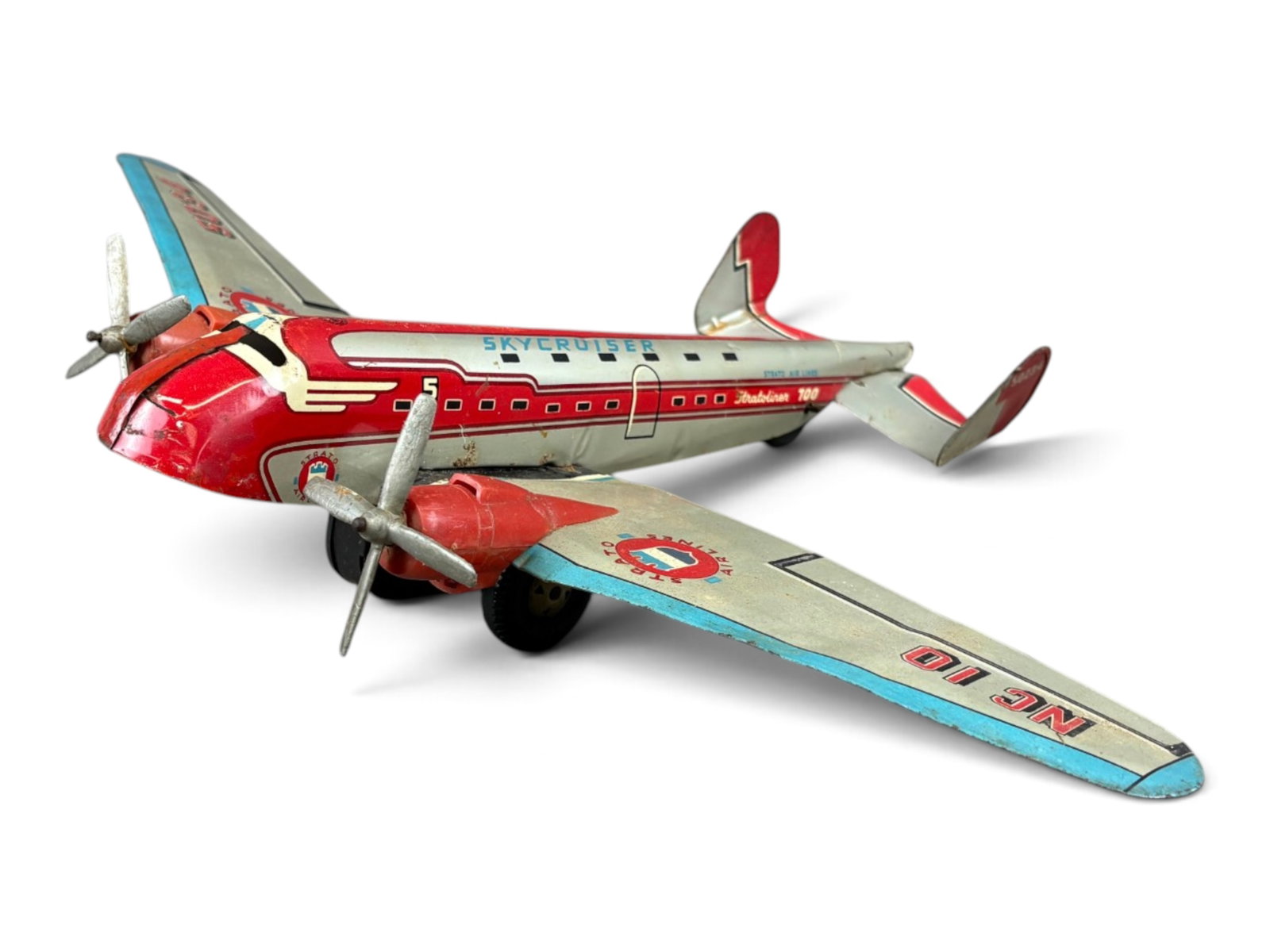 Marx Tin Litho Stratoliner Skycruiser Airplane: Tin lithographed, friction powered. Approx. 13-1/4" long, wingspan approx. 18". Wings marked "NC 10 / Strato Airlines / 5034". Both of the red propeller engines pieces have cracks. Friction wheels