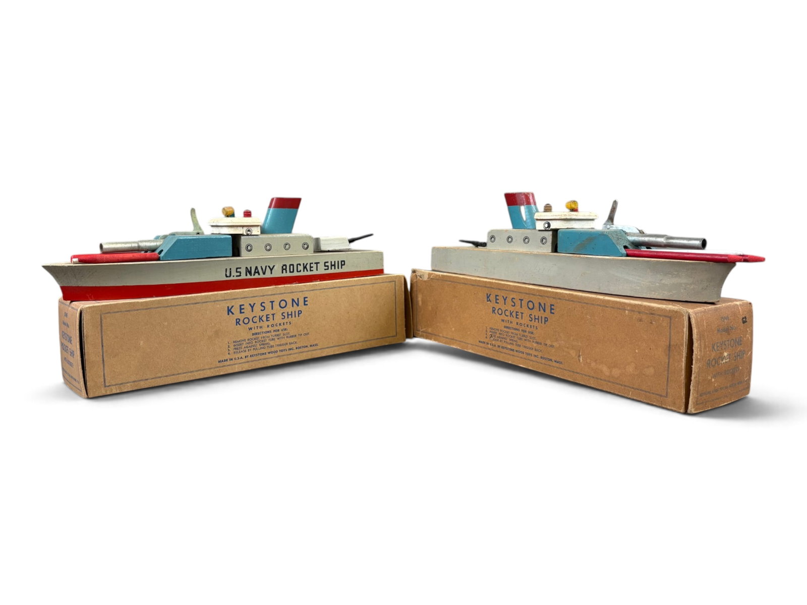 (2) Boxed Keystone US Navy Rocket Ship Boat Toys: Circa 1940's, (2) wooden Keystone U.S. Navy Rocket Ship boats with rockets. Each ship is approx. 13-3/4" long. One of the ships has 2 turrets on the rear. Both ships show overall playwear with scuffs 