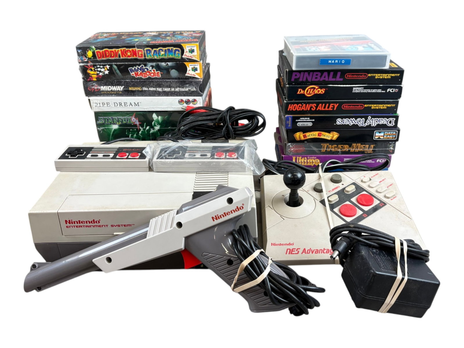 Estate Video Game Lot, NES & Nintendo 64: Estate video game collection featuring an original Nintendo Entertainment System (NES) console with (2) controllers, Zapper light gun, NES Advantage controller, power cords, and assorted games.