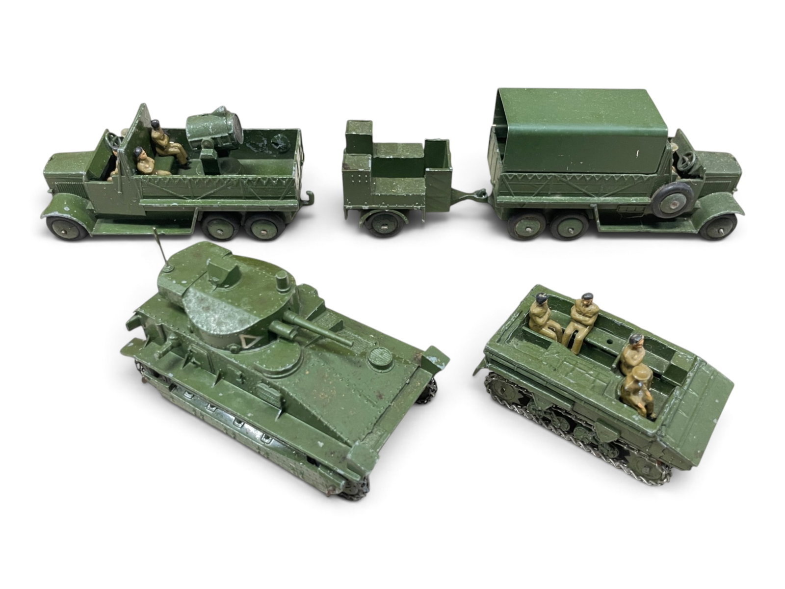 5 Early Dinky Military Vehicles: Includes a 3-Tin lorry on tracks with 6 figures, Cooker trailer, broken rear hitch; Dragon Tank with 23 figures; Searchlight Lorry with crew; 12-ton Medium Mark II tank. All show light to moderate