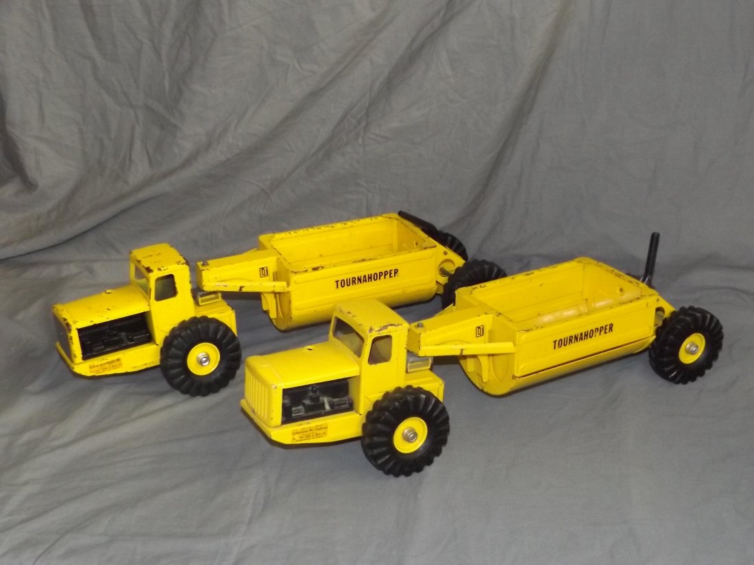 2 Pressed Steel Nylint Tournahopper Trucks: Approx. 24" long. Both show overall wear with paint scuffs, scratches, etc. Lever operated dump doors.