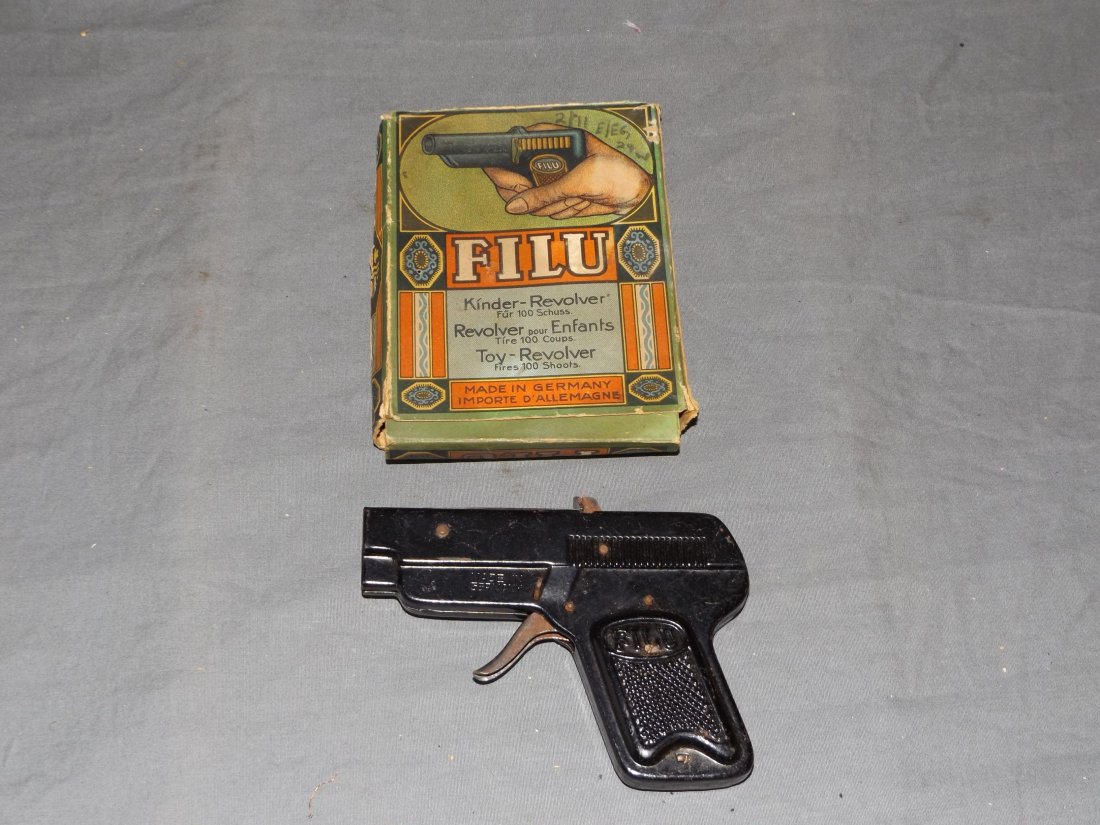 Scarce German FILU Cap Pistol Revolver with Box: Early "FILU" cap pistol revolver, made in Germany. Approx. 4.5" long. Trigger mechanism works well. Comes in the original box which shows some wear, torn missing endflaps, creases, etc.