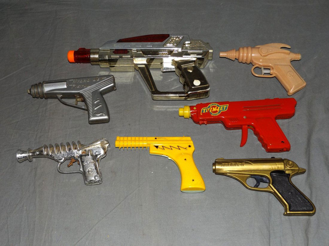 Lot of Vintage Assorted Space Toy Guns: Includes metal thinjet waterpistol, space invader ray water gun, hydro jet pistol, and others. All show some wear with scuffs, scratches, etc. One of the plastic guns has a broken trigger.