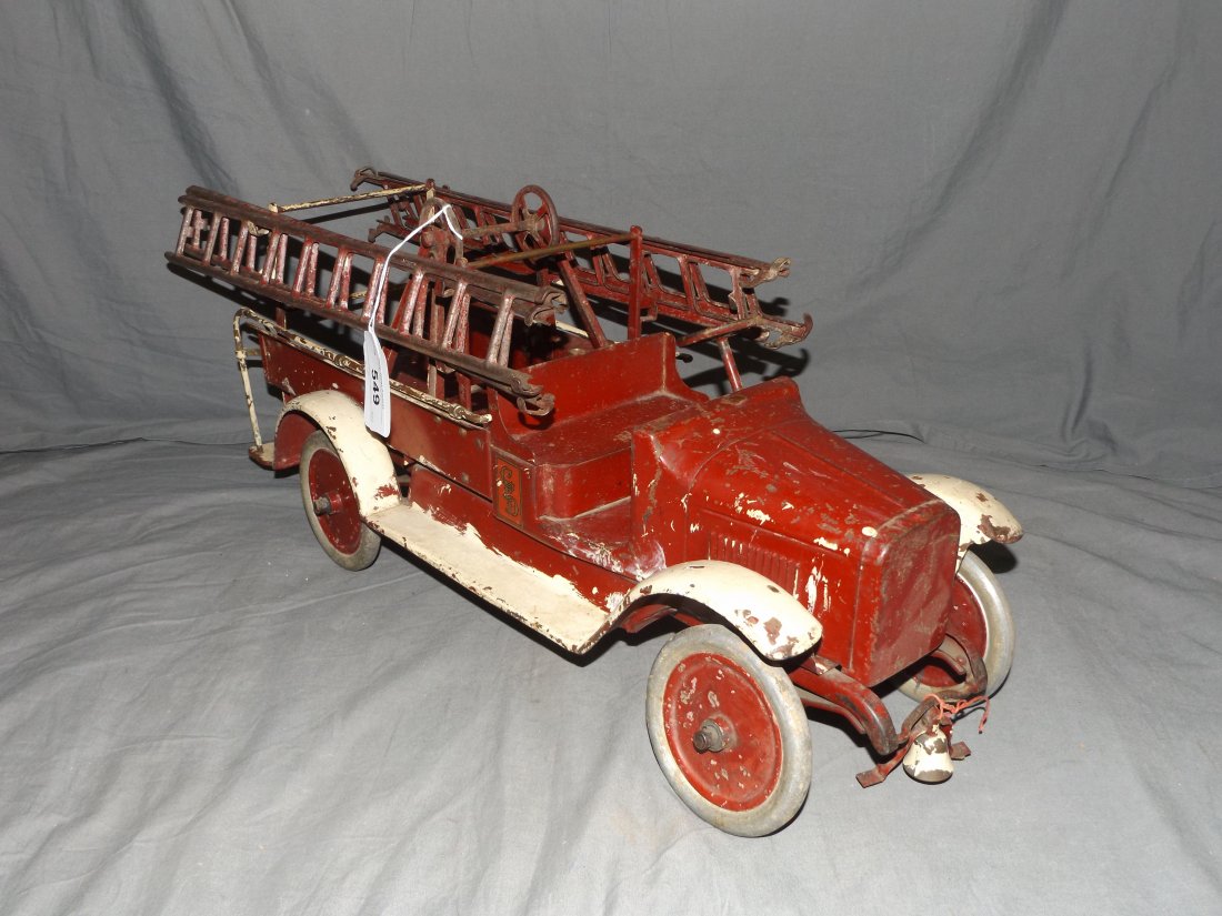 Buddy L Hook and Ladder Truck.: Needs restoration, has been over painted on the bumper and running board. Has 4 ladders but a good restoration is in order. 26" long.