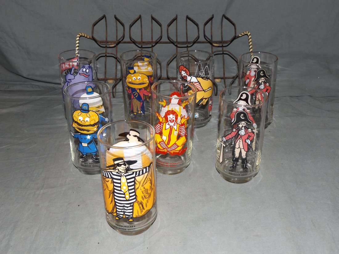 (8) 1977 McDonalds Drinking Glasses with Holder: (8) 1977 McDonalds Drinking Glasses with metal holder, includes Ronald, Mayor McCheese, Hamburglar, Ronald Action Series, Grimace, Big Mac, (2) Captain Crook,