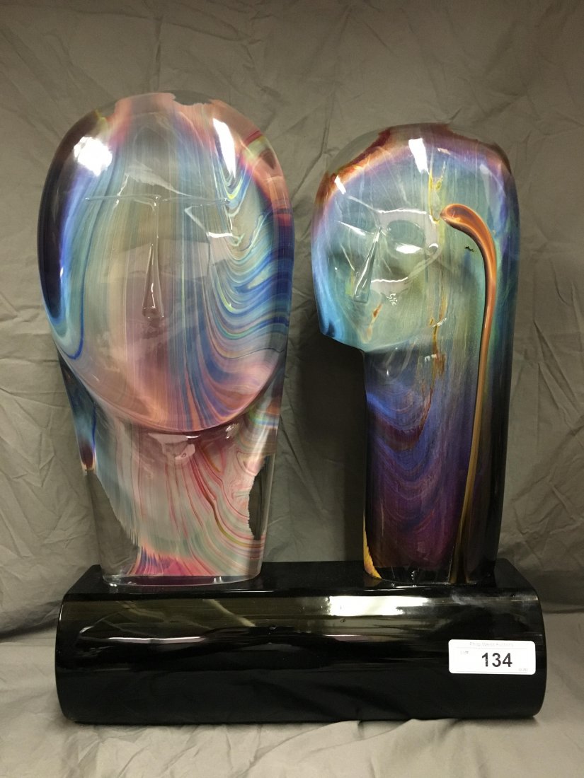 Dino Rosin "Couple" Glass Sculpture: Lot consists of a hand blown glass sculpture by Dino Rosin. Piece depicts two heads representing a man and a woman which are mounted to a hand blown black glass base. Sculpture is done with the calced