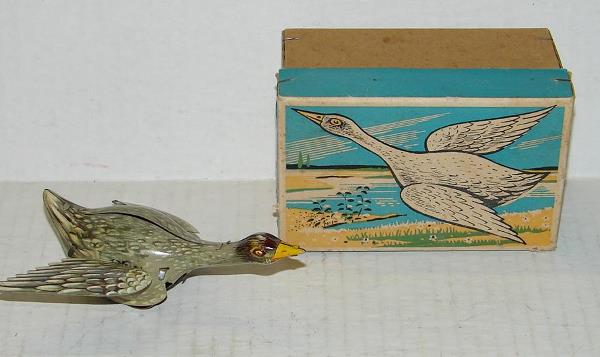 BOXED TIN LITHO WIND UP GOOSE GERMANY: LOT CONSISTS OF A VINTAGE, BOXED TIN LITHO WIND UP GOOSE, MADE IN GERMANY. APPEARS TO HAVE THE MARK "GNK". WIND UP MECHANISM WORKS, HOWEVER ONLY ONE OF THE WINGS FLAP WHEN TOY IS WOUND. THE WIND THAT