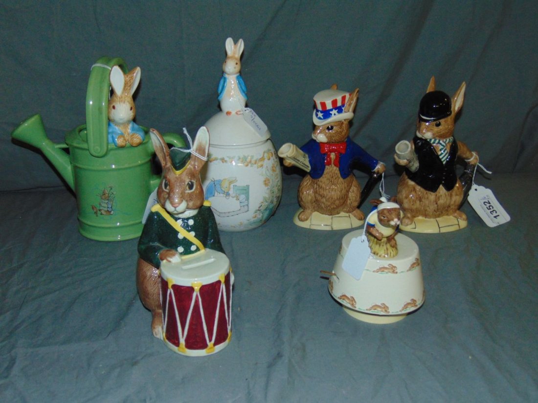 Doulton Bunnykins Tableware and more. Lot of 6.: Lot includes Bunnykins Teapot of the World -- London City Gent - D 6966 and U.S.A .President -D 6996, Bunnybank - D 6615, Bunnykin Music Box - plays King of the Road, Aand two different Beatrix Potter