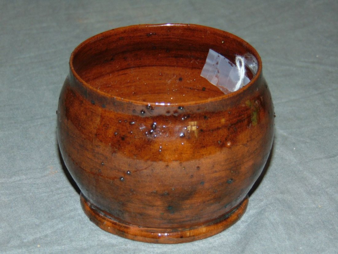 George Ohr Glazed Pottery Bowl: Approx. 3.5" x 3". Incised on the bottom "G.E. Ohr, Biloxi, Miss". Thin crack along the bottom that runs up the side. Some chips to the bottom edge.
