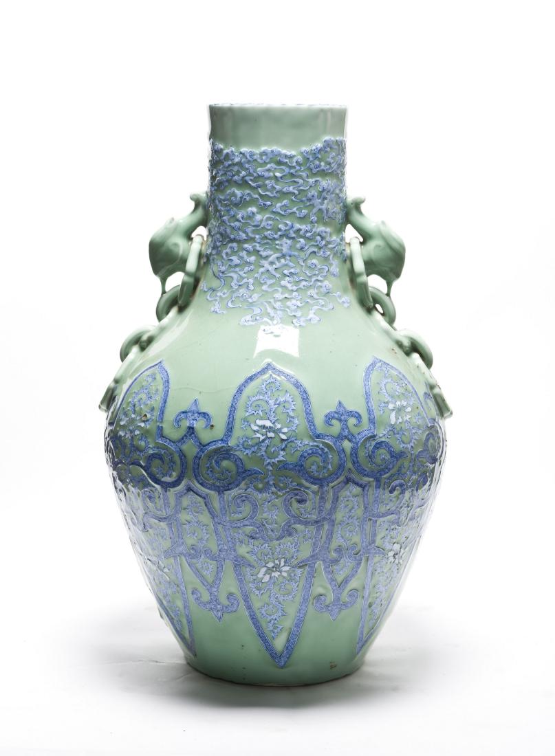 A Rare Dou Qing Glazed with Blue & White incised Vase: The compressed body, spreading foot, waisted neck, and out-turned, are carved with bands of blue and white foliate patterns overlaying with incised details. The neck is flanked by a pair of openwork d