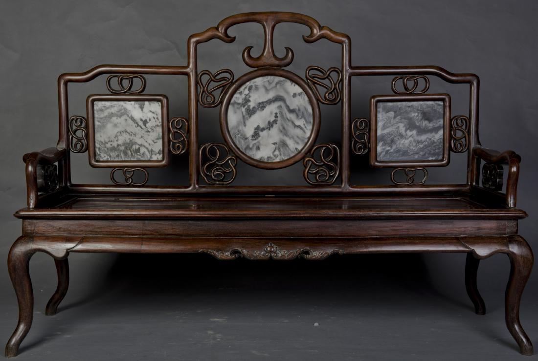 A MARBLE INLAID ROSEWOOD SETTEE: A Chinese carved rosewood settee, the chair back carved in openword design and inlaid with marbles, all supported on four legs terminating in hoof feet. Height 44'' Width 21.5'' Length 63''