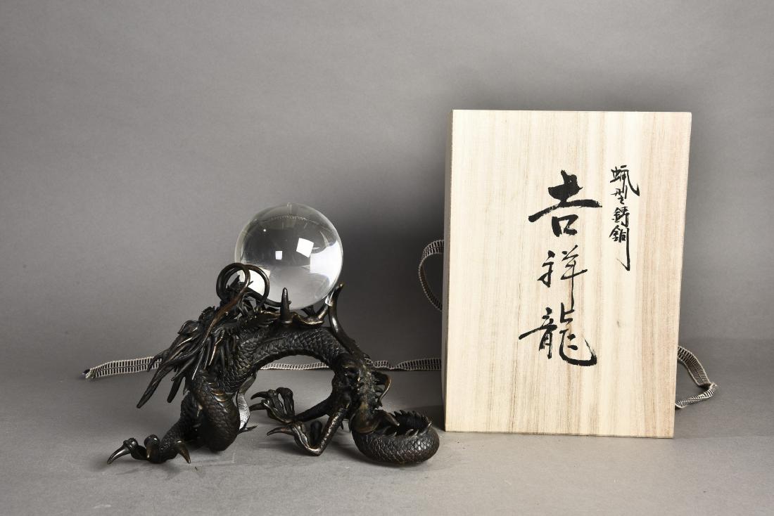A 'DRAGON' BRONZE SCULPTURE WITH CRYSTAL BALL, 20TH: Then bronze dragon sculpture holding with a fine crystal ball. With a Japanese wood box. Height 7'' Width 8''